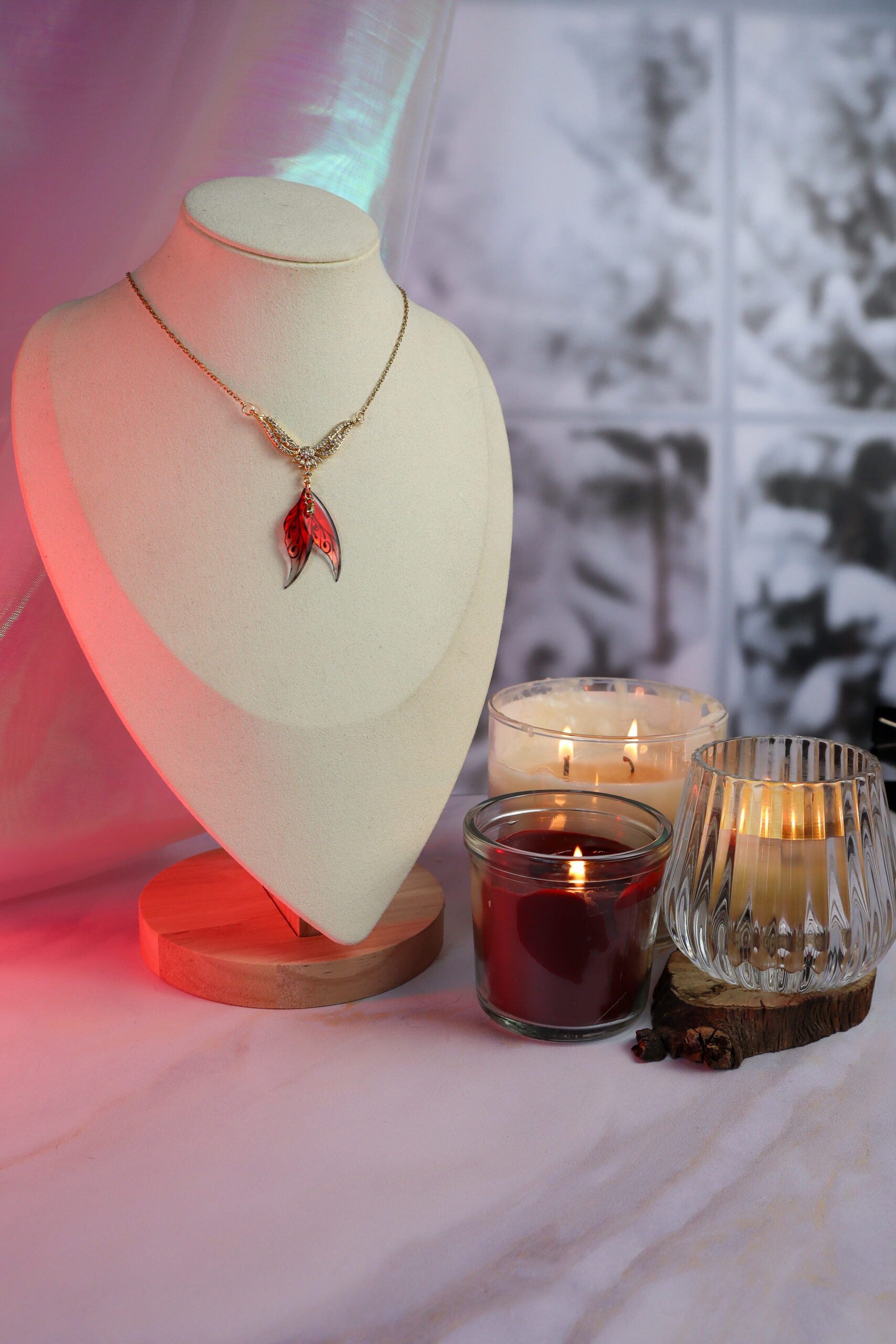 collier l'élue zoom sur les ailes de fées rouges avec des reflets et le pendentif